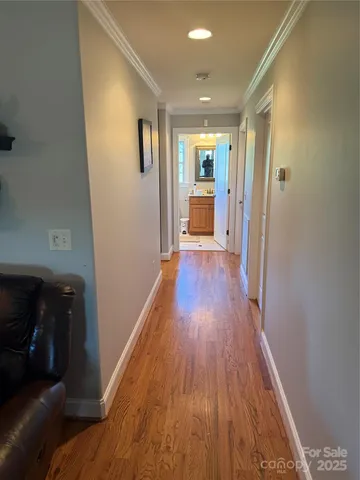 a view of a hallway with wooden floor and windows