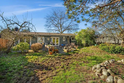 a view of a house with a yard and sitting area