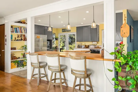a kitchen with stainless steel appliances kitchen island granite countertop a table and chairs in it