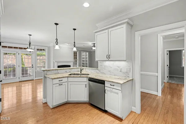 a kitchen with a sink stove and wooden floor
