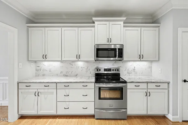 a kitchen with white cabinets and appliances