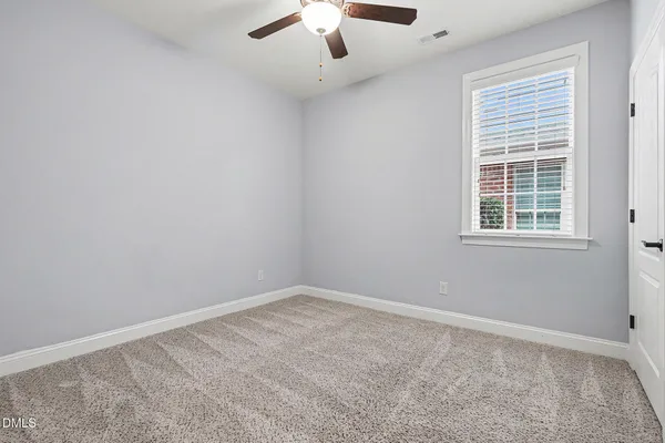 an empty room with closet and a chandelier fan