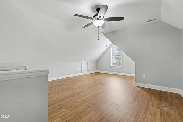 wooden floor in an empty room with a fan