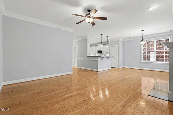 a view of a kitchen with wooden floor and a ceiling fan