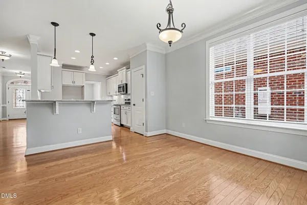 a view of a kitchen with a dishwasher wooden cabinets and a large window