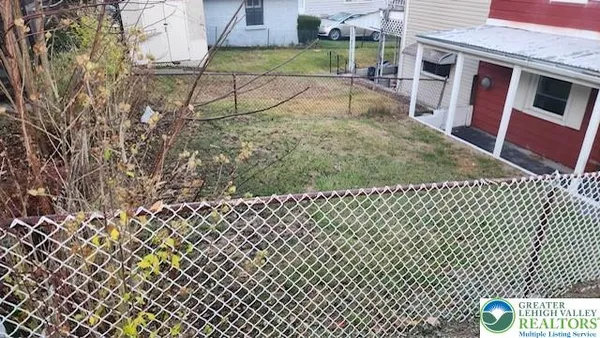 an empty room with wooden floor chandelier and windows