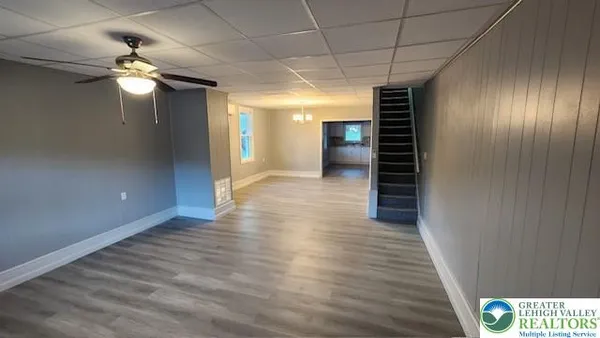 a view of a livingroom with wooden floor and staircase