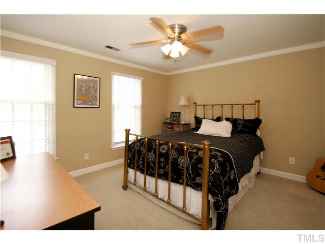 7900 Farmingwood Lane Raleigh, NC 27615 - Photo 17 of 25 a bedroom with a bed and a chandelier