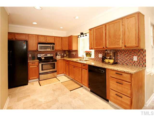 7900 Farmingwood Lane Raleigh, NC 27615 - Photo 3 of 25 a kitchen with a sink a stove and refrigerator