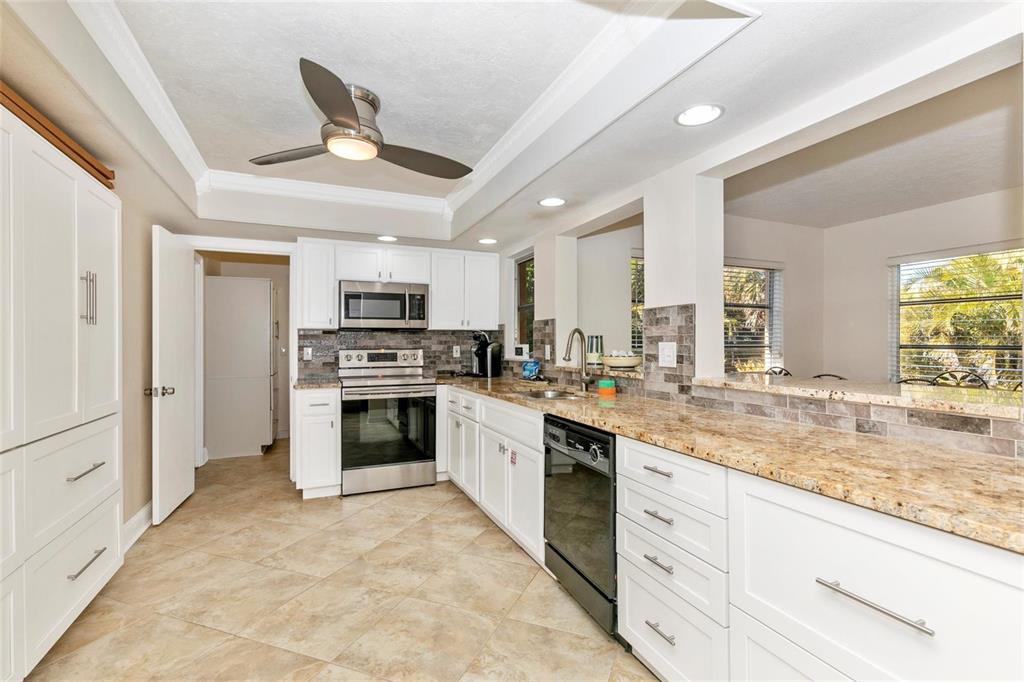 3039 Chase Circle Sarasota, FL 34231 - Photo 24 of 55 a kitchen with granite countertop a stove top oven and cabinets