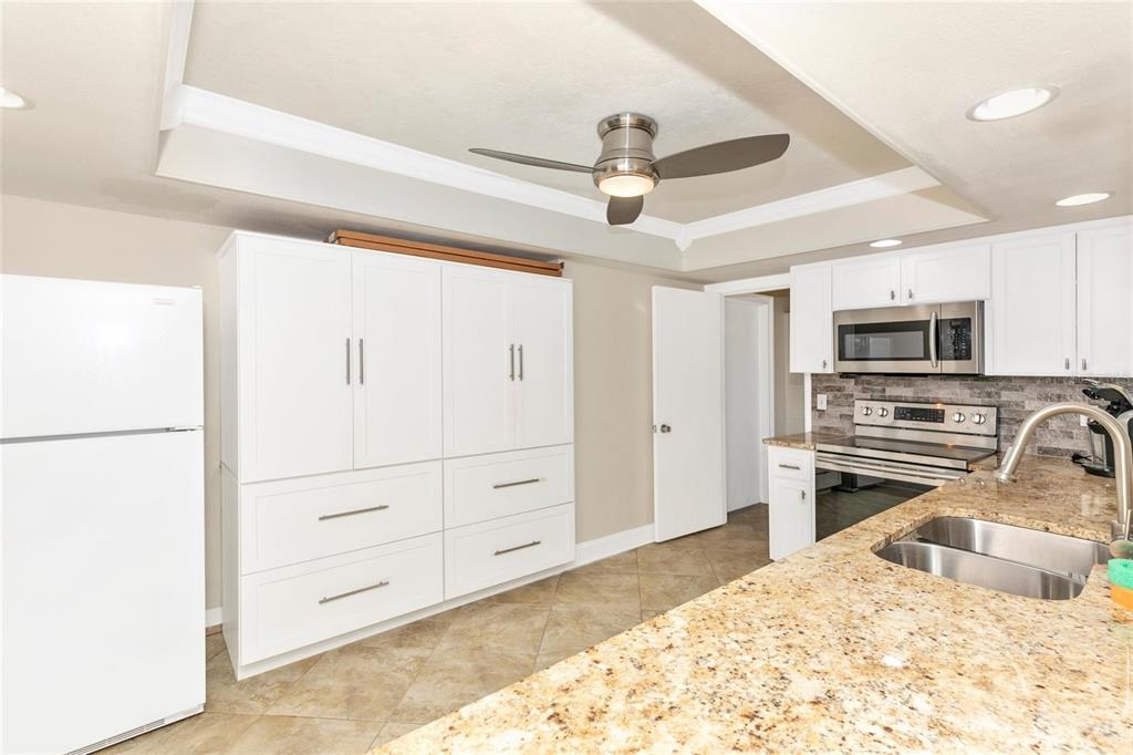 3039 Chase Circle Sarasota, FL 34231 - Photo 29 of 55 a kitchen with a refrigerator stove and white cabinets