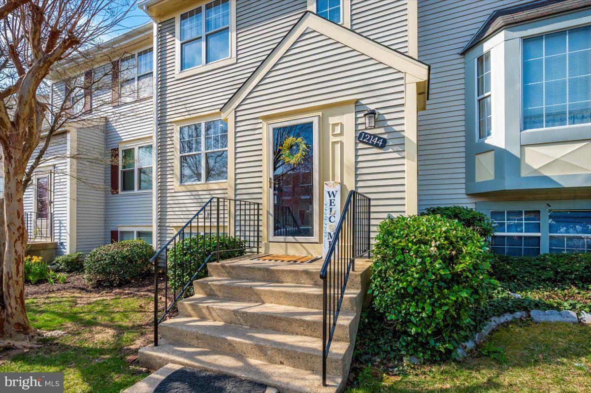 a front view of a house with plants and entryway