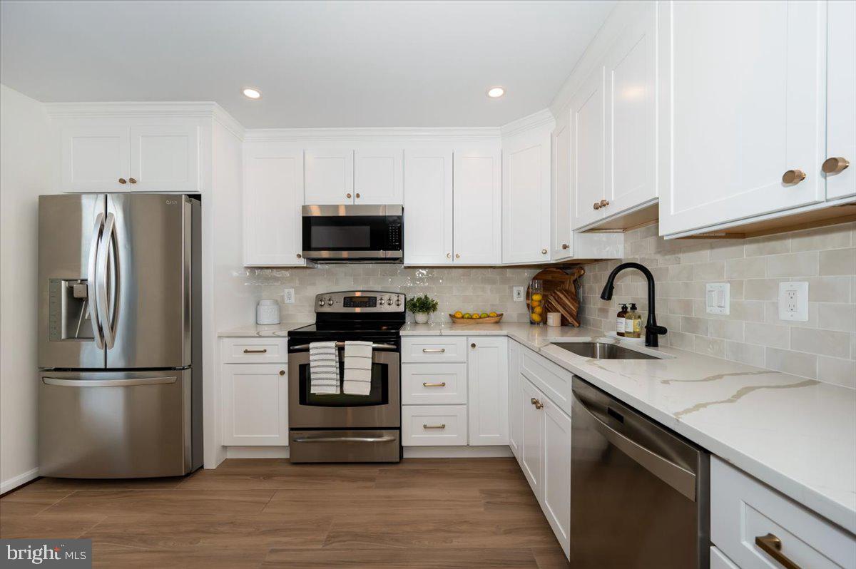 12144 Turnstone Court, Unit 87 Silver Spring, MD 20904 - Photo 11 of 56 a kitchen with refrigerator a sink and white cabinets