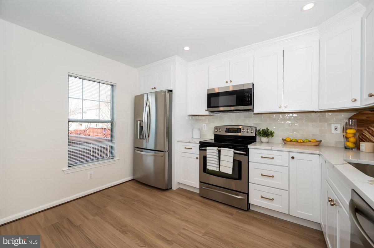 12144 Turnstone Court, Unit 87 Silver Spring, MD 20904 - Photo 12 of 56 a kitchen with a refrigerator stove and wooden cabinets