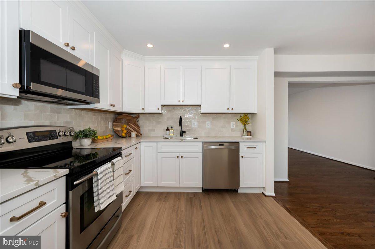 12144 Turnstone Court, Unit 87 Silver Spring, MD 20904 - Photo 13 of 56 a kitchen with stainless steel appliances granite countertop a stove a sink and a microwave