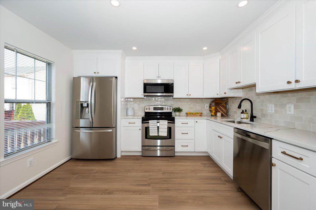 12144 Turnstone Court, Unit 87 Silver Spring, MD 20904 - Photo 17 of 56 a kitchen with granite countertop a refrigerator stove and microwave