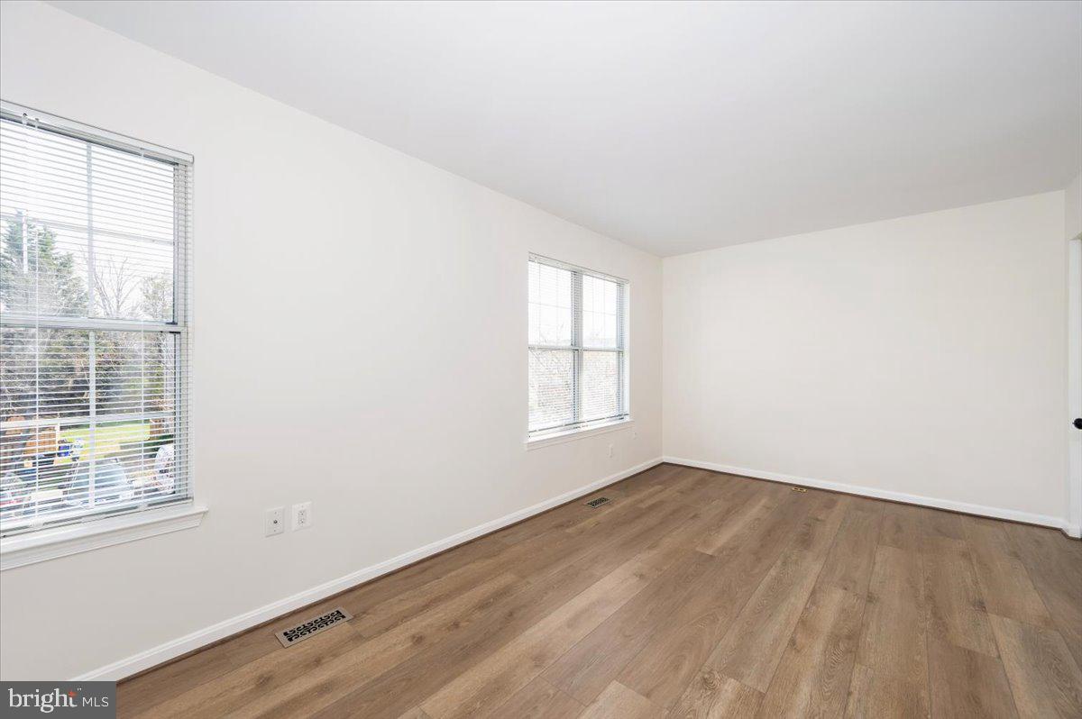12144 Turnstone Court, Unit 87 Silver Spring, MD 20904 - Photo 32 of 56 an empty room with wooden floor and windows
