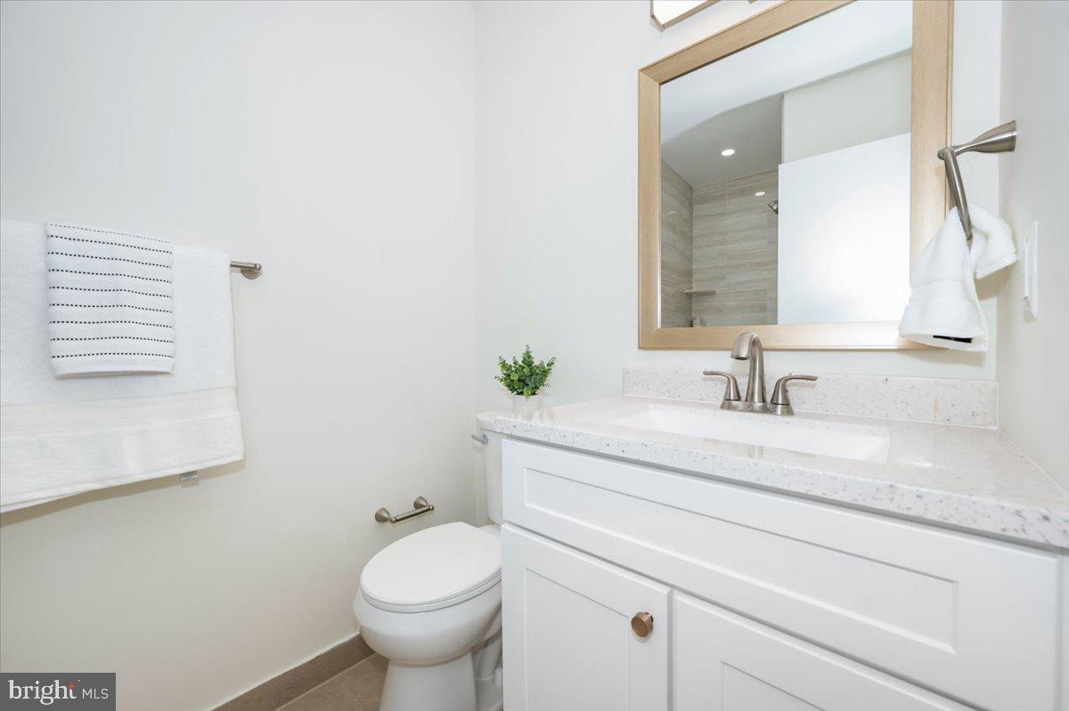 12144 Turnstone Court, Unit 87 Silver Spring, MD 20904 - Photo 41 of 56 a bathroom with a granite countertop toilet sink and mirror