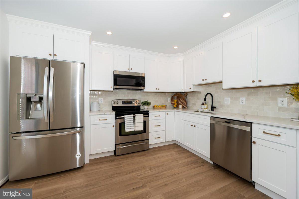 12144 Turnstone Court, Unit 87 Silver Spring, MD 20904 - Photo 9 of 56 a kitchen with cabinets stainless steel appliances and wooden floor