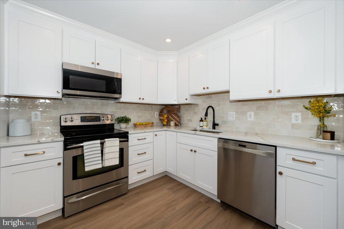 12144 Turnstone Court, Unit 87 Silver Spring, MD 20904 - Photo 10 of 56 a kitchen with granite countertop white cabinets white stainless steel appliances and a sink