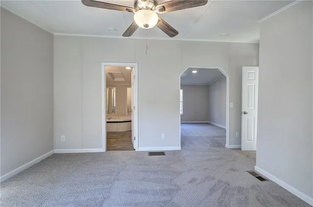 an empty room with closet and a chandelier fan