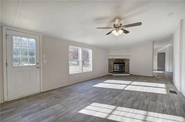 a view of an empty room with a window and a kitchen