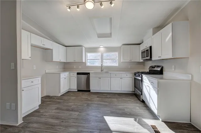a kitchen with stainless steel appliances cabinets a sink and a stove