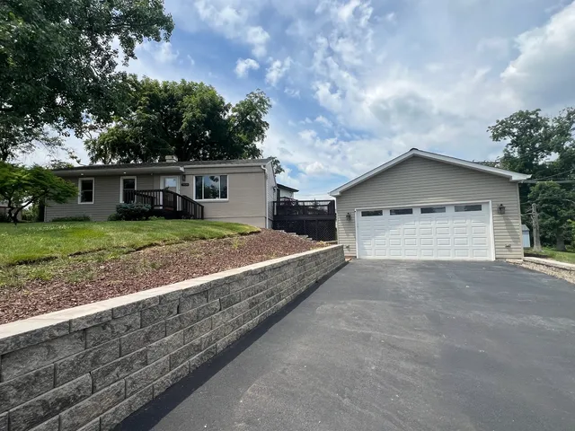 a view of a house with a yard and large tree