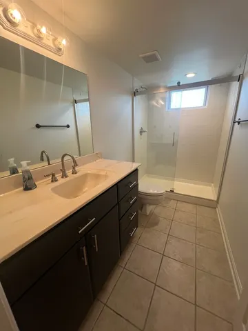 a bathroom with a sink mirror and shower