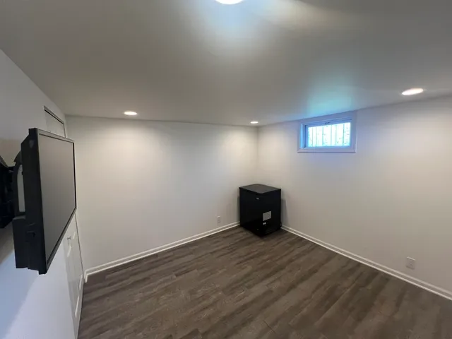 an empty room with wooden floor and a window
