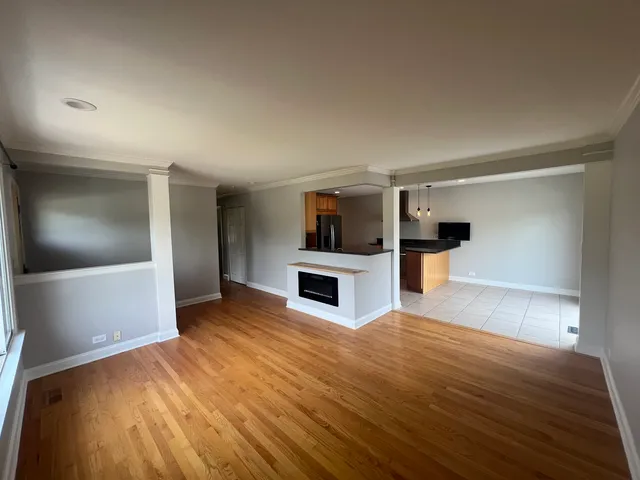 a view of empty room with wooden floor