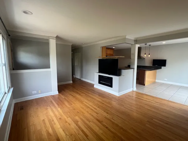 a view of a kitchen with wooden floor and electronic appliances