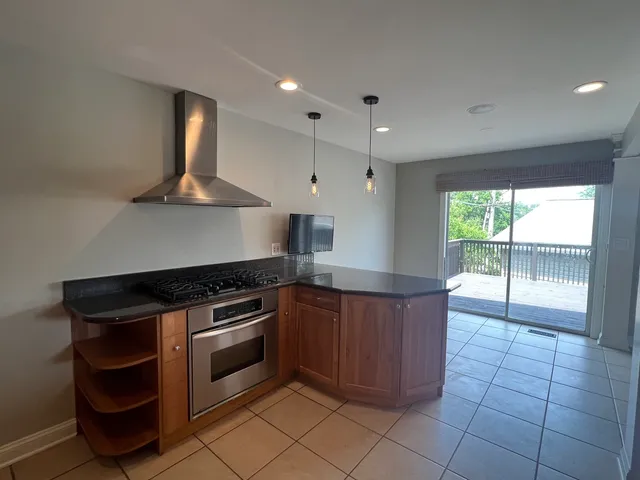 a kitchen with stainless steel appliances granite countertop a stove a sink and a microwave