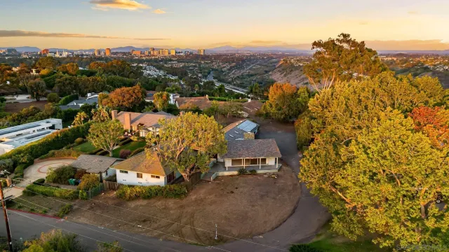 an aerial view of a house with a yard and lake view