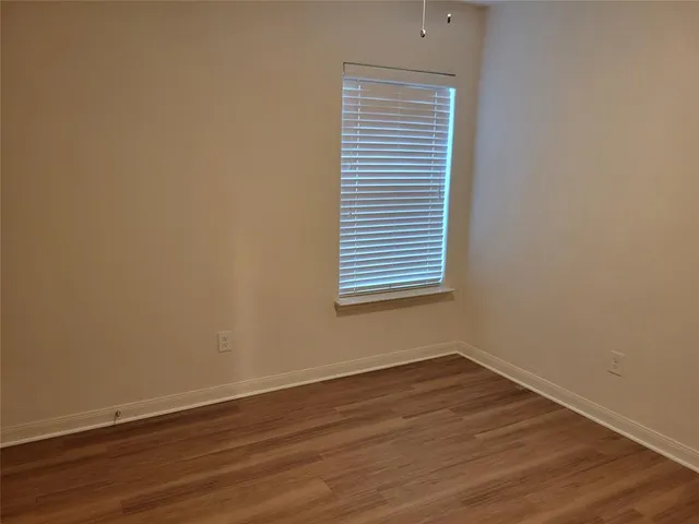 an empty room with wooden floor and a window