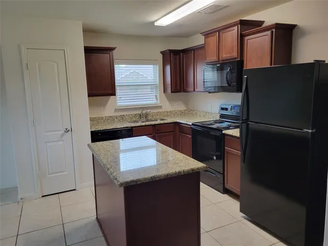 a kitchen with a sink a refrigerator and cabinets