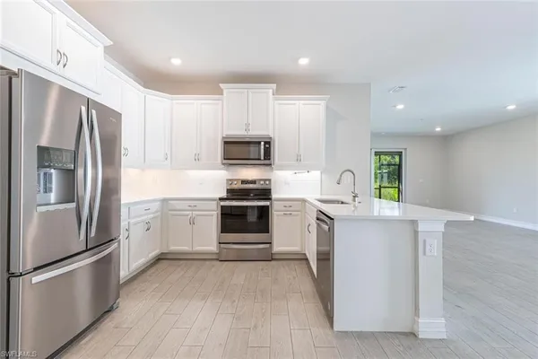 a kitchen with stainless steel appliances a refrigerator sink and microwave