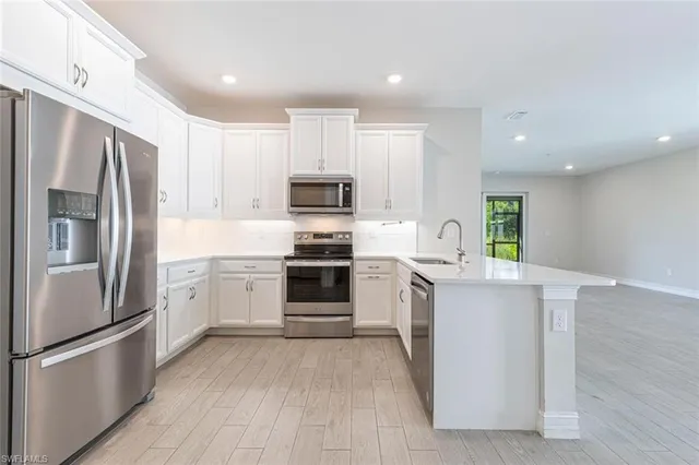 a kitchen with stainless steel appliances a refrigerator sink and microwave