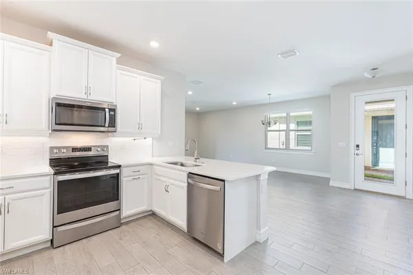 a kitchen with a sink stove top oven and microwave