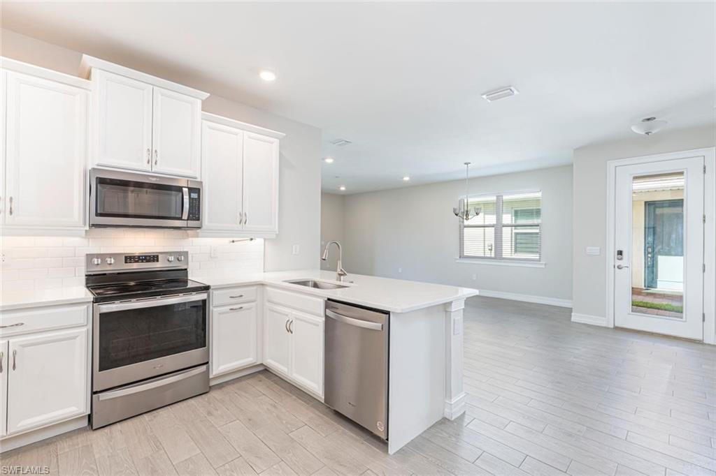 1050 Enbrook Loop Naples, FL 34114 - Photo 4 of 29 a kitchen with a sink stove top oven and microwave