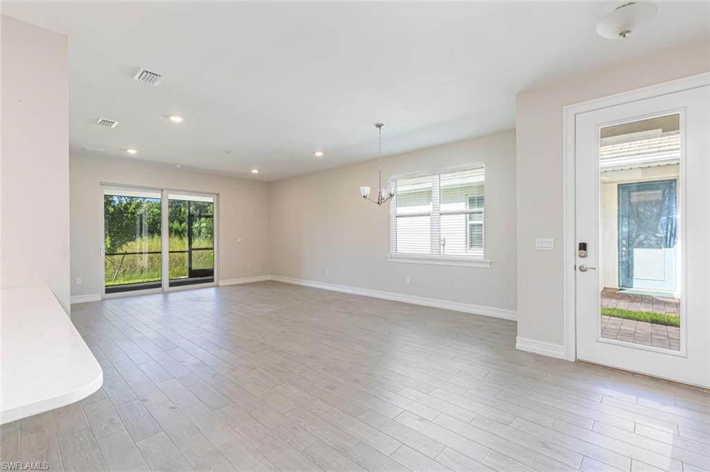 1050 Enbrook Loop Naples, FL 34114 - Photo 6 of 29 a view of an empty room with wooden floor and a window