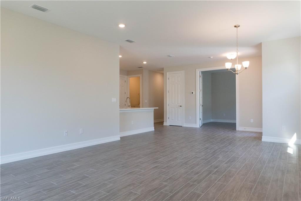 1050 Enbrook Loop Naples, FL 34114 - Photo 7 of 29 wooden floor in an empty room with a mirror