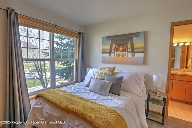 a bed sitting in a bedroom next to a window