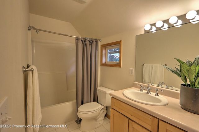 a bathroom with a sink a toilet a mirror and shower