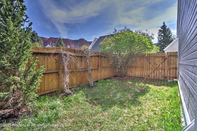 a view of a backyard with wooden fence