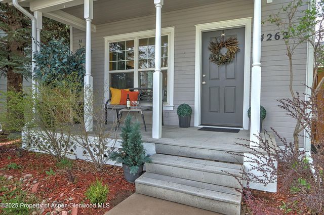 a front view of a house with a yard and potted plants