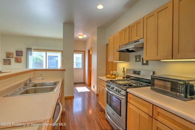 a kitchen that has a sink and a stove top oven