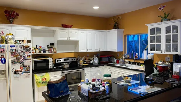 a kitchen with a refrigerator and a stove top oven