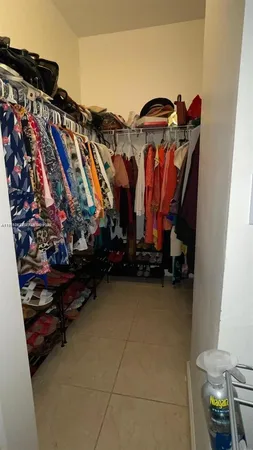 a view of walk in closet with clothes and shoes