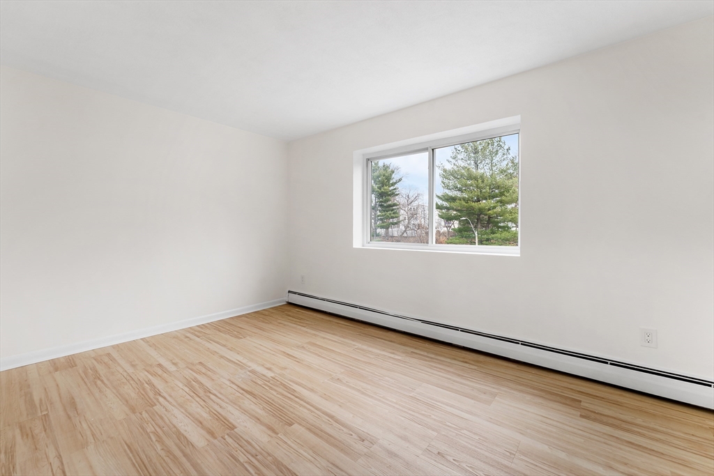 34 Hamilton Road, Unit 302 Arlington, MA 02474 - Photo 16 of 30 an empty room with wooden floor and windows